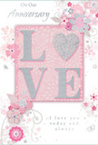 This anniversary card portrays enduring romance with the softness of an English spring garden, the kind you might glimpse in front gardens around New Addington as the season turns. At the centre, the word "LOVE" stands proudly in raised, softly glittering letters, each stroke defined yet gentle. The "O" is transformed into a shimmering heart, textured in silver and slightly embossed so it can be felt when fingertips pass over it, like tracing the curve of a polished charm. Around this focus point, a halo of delicate blooms in blush, pale pink, and muted mauve opens outward with a watercolour-like softness. The petals are not sharply outlined; instead they blend into the pale background with fine, flowing lines, evoking both lightness and thoughtful care, much like a carefully composed anniversary bouquet delivered by a local florist. Tiny decorative flourishes-small petals, looping swirls, and discreet butterflies-add a sense of movement, as though a gentle breeze has just stirred the arrangement. The inscriptions "On Our Anniversary" and "I love you today and always" appear in a slender, elegant script, unobtrusive yet full of warmth, woven into the design without overpowering the delicate florals. Overall, the card feels calm and intimate, its pastel pinks and silvery greys creating a keepsake that honours shared years and quiet promises, ideal for marking a milestone at home after a peaceful walk through New Addington's neighbourhood streets.